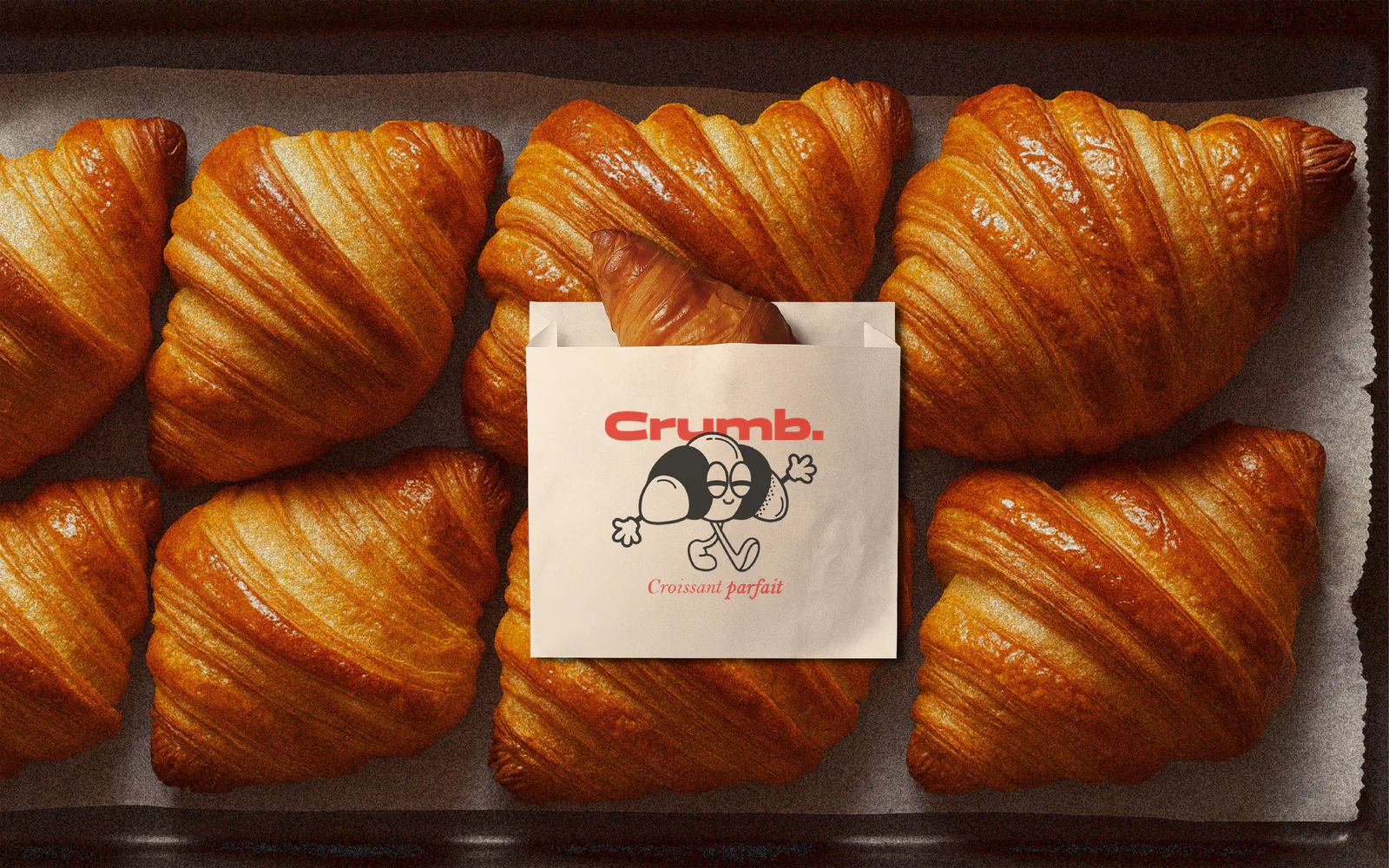 Sachet Crumb. posé sur une plaque de croissants dorés