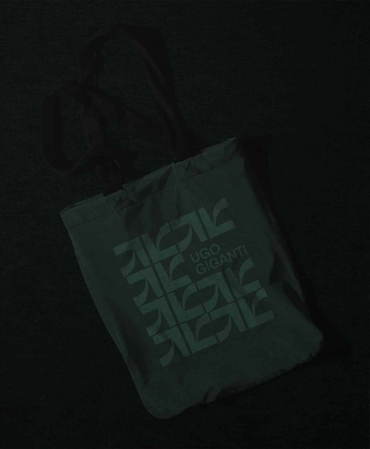 Tote bag vert sombre imprimé d'un motif de monogrammes et du nom Ugo Giganti