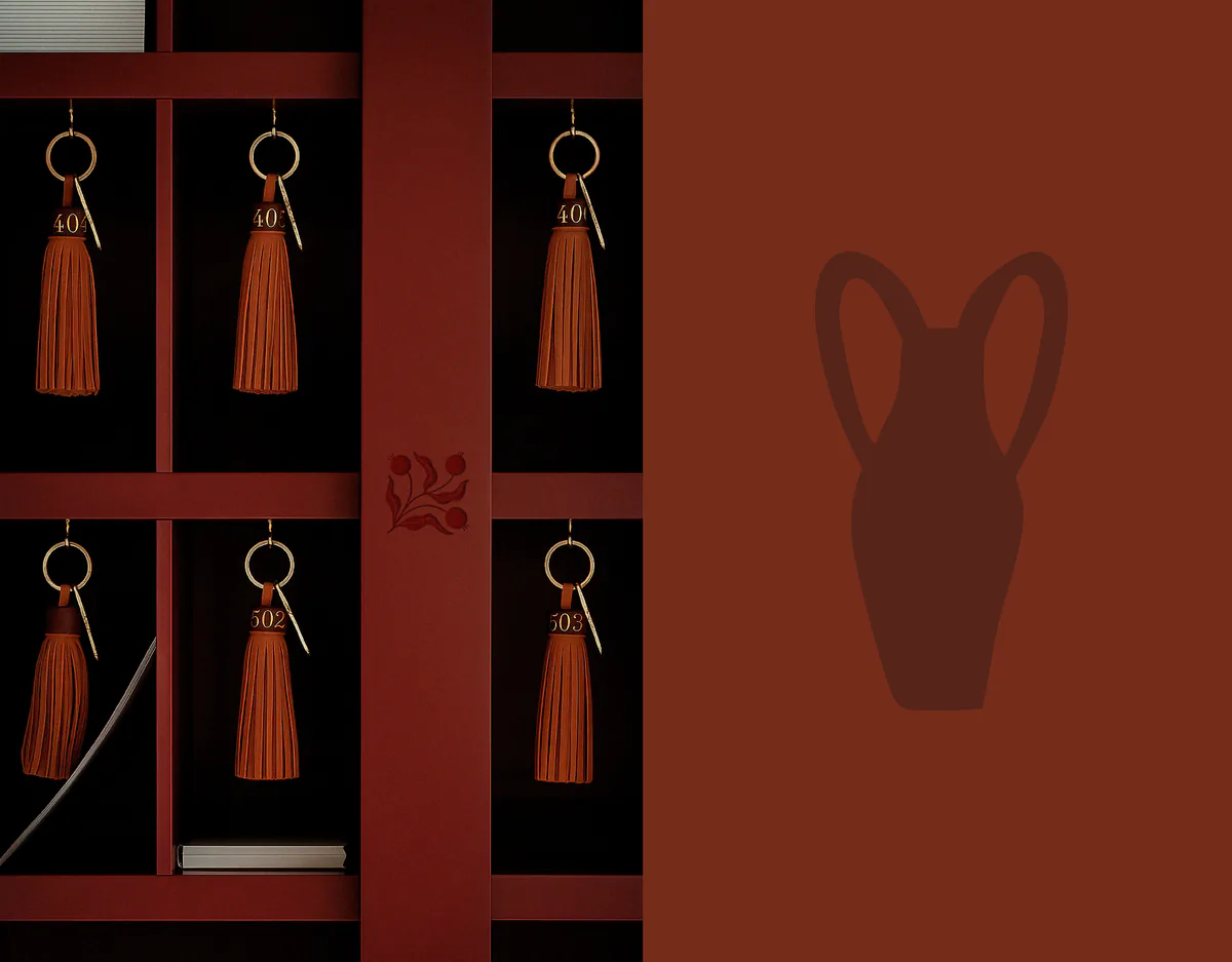 Porte-clés à pompon de l'hôtel et emblème gravé, à côté d'un pictogramme d'amphore