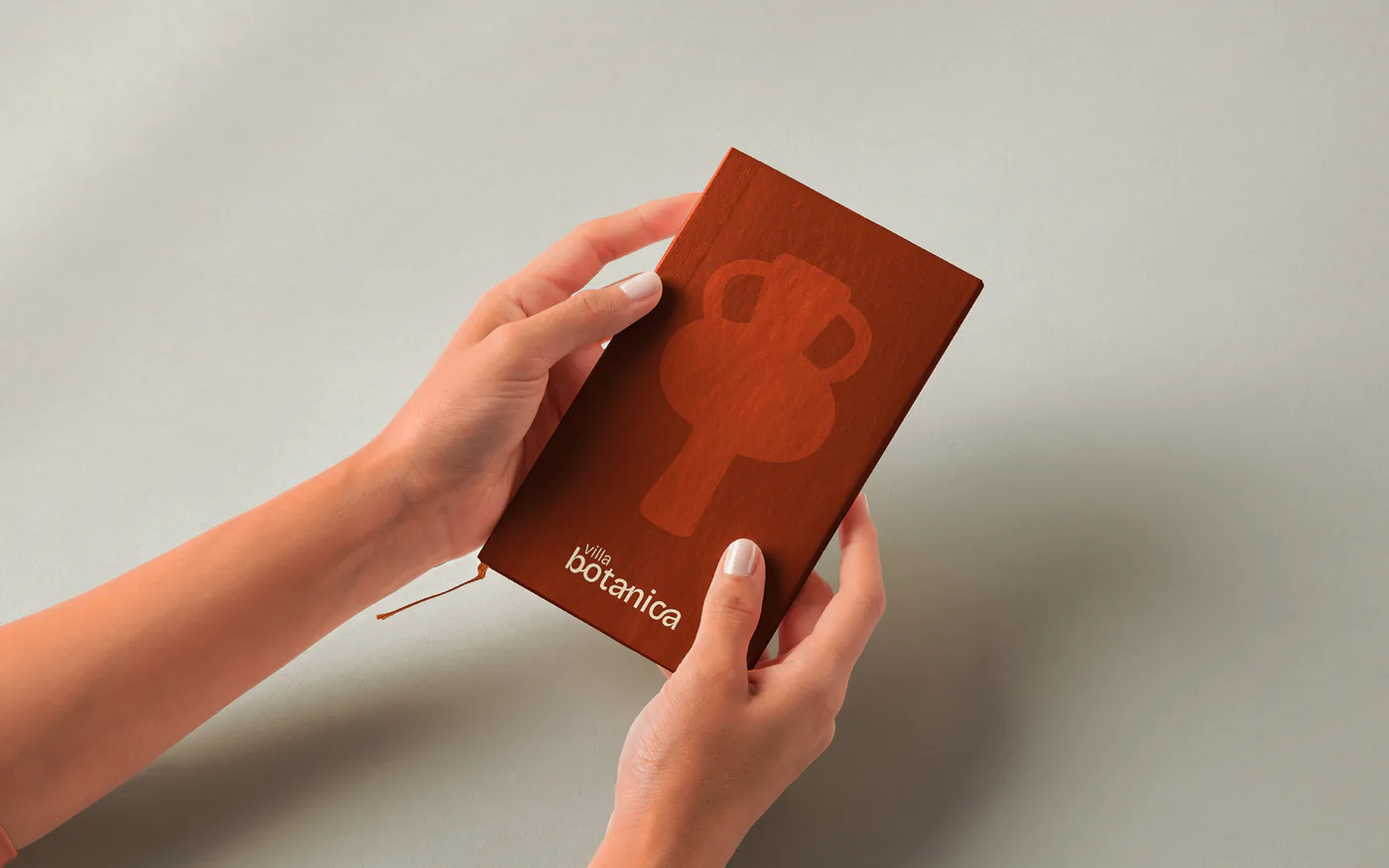 Carnet terracotta Villa Botanica tenu en main : identité d'hôtel par MATE Studio